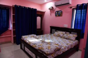 a bedroom with a bed with purple walls at Vasavi Homestay in Mādhavaram