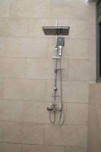 a shower with a hose attached to a wall at Urban Two BR Condo Near Najjera Hospital in Kampala