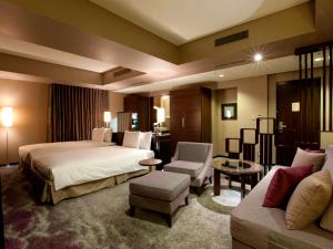 a hotel room with two beds and a couch at The Royal Park Hotel Iconic Tokyo Shiodome in Tokyo