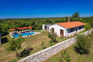 ein Haus mit einem Swimmingpool neben einer Steinmauer in der Unterkunft Villa Mina - Orihi in Orihi