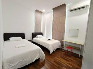 a room with two beds and a table and a chair at Jk CozyStay 10Pax 300Mbps 3BedR 2BathR 2ShadedCarpark in Kuching +40 photos