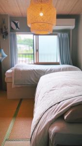 Un dormitorio con una cama y una ventana grande. en 民泊宿 i s e s h i m a 伊勢内宮前203, en Ise