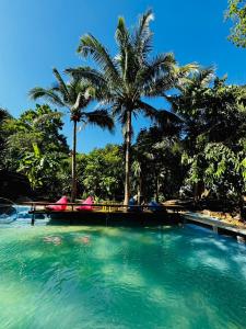 a swimming pool with palm trees in a resort at Ingphu Mountainview Khao Yai in Ban Khan Takhian