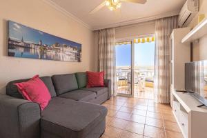 a living room with a couch and a television at Seaside Escape 2bed By Dream Homes Tenerife in Puerto de Santiago