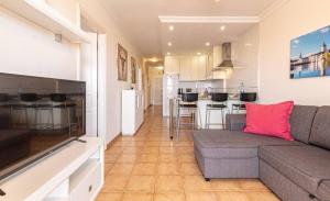 a living room with a couch and a kitchen at Seaside Escape 2bed By Dream Homes Tenerife in Puerto de Santiago