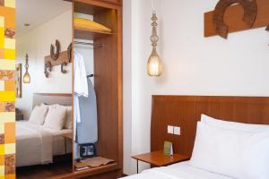a hotel room with a bed and a mirror at MERUSAKA Nusa Dua in Nusa Dua