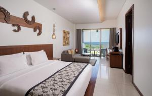 a bedroom with a bed and a living room at MERUSAKA Nusa Dua in Nusa Dua