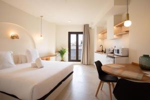 a bedroom with a bed and a table and a kitchen at Reina Victoria El Mercado in Alicante