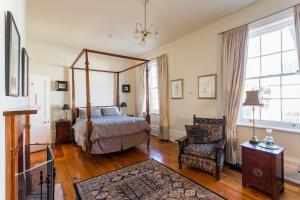 a bedroom with a canopy bed and a chair at Grand Old Duke in Hobart