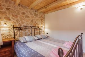 a bedroom with a bed and a stone wall at Villa Stone Valcer in Slivno +67 photos