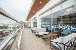 伊洛伊洛Figtree Hotel的建筑物上的带桌椅的阳台