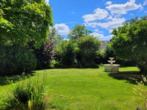 a garden with a fountain in the middle of a lawn at Ferienwohnung Westerwaldblick großzügige Wohlfühloase mit Terrasse in Oberelbert