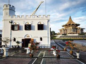 a white building with flowers in front of a building at Jk Home 12Pax 500Mbps 10Beds 4BathR 2Carparks in Kuching