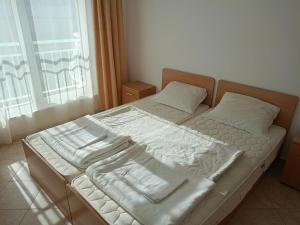 a bed with white sheets and pillows in a bedroom at CunninghamsSilver in Sunny Beach