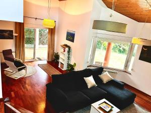 a living room with a black couch and a window at Casa Vixoi, a 5Km Catedral in Santiago de Compostela