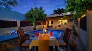 a table and chairs in a backyard with a pool at TreeHouse The Pugmark, A Wildlife Resort in Sawāi Mādhopur