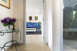a living room with a blue couch and a glass table at Apartment Design - Terrazzo, vista lago mozzafiato in Caslano