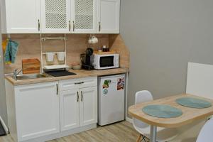 a small kitchen with a white refrigerator and a table at Art Studio Sea in Shkorpilovtsi