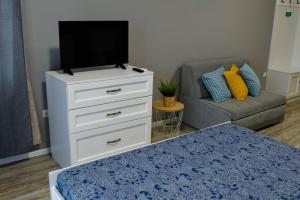 a living room with a tv on a dresser and a couch at Art Studio Sea in Shkorpilovtsi