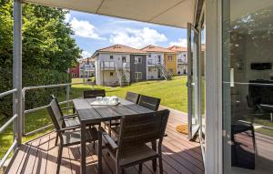 een terras met een tafel en stoelen op een dek bij Gudhjem Søpark Lejl 25 in Gudhjem +16 foto's