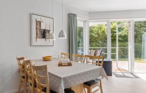 een eetkamer met een tafel en stoelen en een raam bij Gudhjem Søpark Lejl 25 in Gudhjem