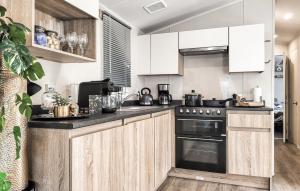 heinkenszandにある3 Bedroom Lovely Home In Heinkenszandのキッチン(白いキャビネット、黒いオーブン付)