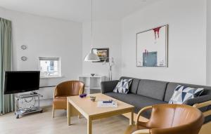 una sala de estar con un sofá y una mesa en Gudhjem Søpark Lejl 16, en Gudhjem