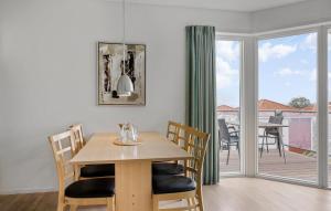 comedor con mesa y balcón en Gudhjem Søpark Lejl 16, en Gudhjem