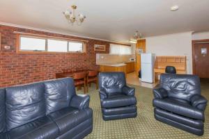 a living room with leather furniture and a kitchen at Bell Motel in Melbourne