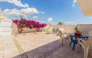 un patio avec des tables et des chaises et des fleurs violettes dans l'établissement Cozy Home In Torrevieja With Wifi, à Torrevieja 18 autres photos