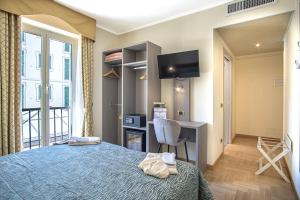 a bedroom with a bed and a desk and a tv at Grande Albergo in Sestri Levante