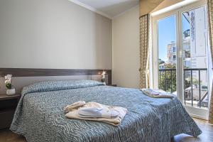 a bedroom with a bed with two towels on it at Grande Albergo in Sestri Levante