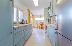 une cuisine avec des armoires bleues et une salle à manger dans l'établissement Cozy Home In Torrevieja With Wifi, à Torrevieja