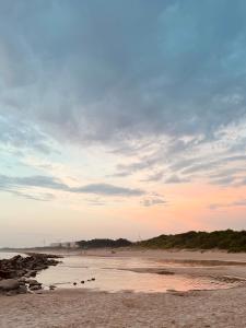 - une vue sur une plage avec un ciel nuageux dans l'établissement Designer Wohnung nur 450 m vom Strand entfernt!, à Darłowo
