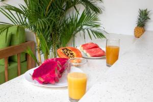 two plates of fruit and two glasses of orange juice at Dive into Bliss - Brand New Seminyak Villa with Private Pool in Seminyak +7 photos