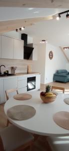 a white kitchen with a table and some chairs at Apartment Korenat in Turanj
