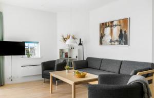 a living room with a couch and chairs and a table at Gudhjem Søpark Lejl 38 in Gudhjem