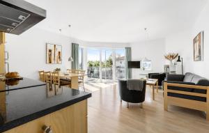 a kitchen and living room with a table and chairs at Gudhjem Søpark Lejl 38 in Gudhjem