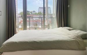 una cama en una habitación con una ventana grande en Amazing Apartment In Egmond Aan Zee, en Egmond aan Zee