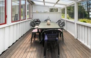a screened porch with a table and chairs on it at 2 Bedroom Stunning Home In Ljungby in Bolmstad