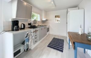 a kitchen with white cabinets and a wooden table at 2 Bedroom Stunning Home In Ljungby in Bolmstad