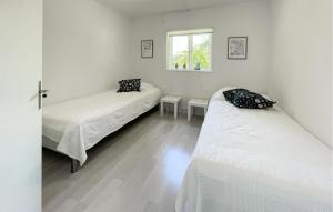 a bedroom with two beds and a window at 2 Bedroom Stunning Home In Ljungby in Bolmstad