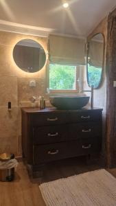 a bathroom with a sink and a tub in a camper at KÄBANE 81, Lodge avec spa au bord de l'eau in Prouilly