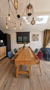 a wooden table in a living room with chairs at KÄBANE 81, Lodge avec spa au bord de l'eau in Prouilly