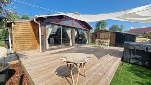 a wooden deck with a chair and a tent at KÄBANE 81, Lodge avec spa au bord de l'eau in Prouilly +6 photos