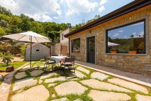 a patio with an umbrella and a table and chairs at SAN LEO, Castellabate - Mafalda in Castellabate