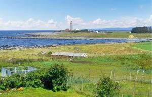 a lighthouse in a field next to the water at 3 Bedroom Gorgeous Apartment In Borhaug in Borhaug +5 photos