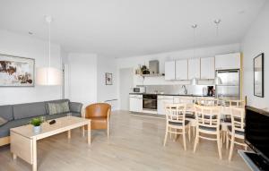 Una sala de estar y una cocina con mesa y sillas. en Gudhjem Søpark Lejl 2, en Gudhjem