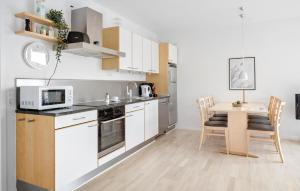 Una pequeña cocina con una mesa y un microondas. en Gudhjem Søpark Lejl 2, en Gudhjem