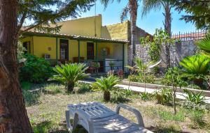 a yellow house with a bench in the yard at Casa Vacanza Scarantino 1 in Catania